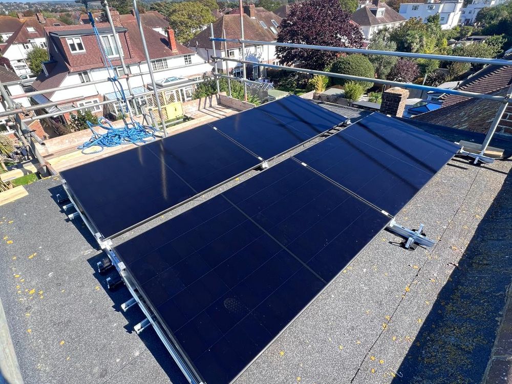A row of solar panels on a flat roof on Van der Valk ballasted frames